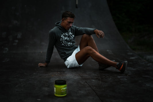 man sitting on skateboard tracks