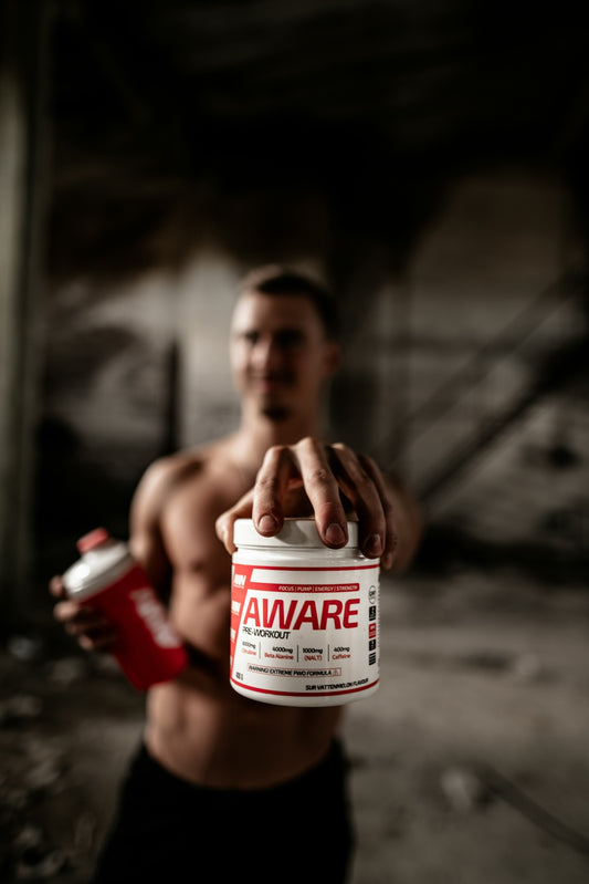 person holding red and white Aware labeled bottle