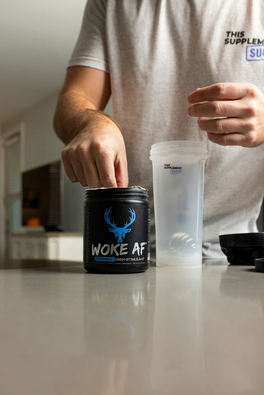 a man holding a can of woke art next to a plastic cup