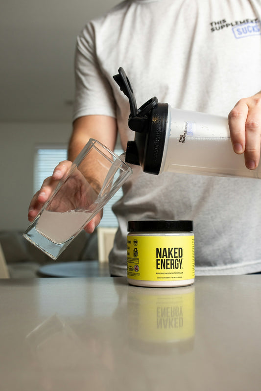 a person pouring a glass of water into a container
