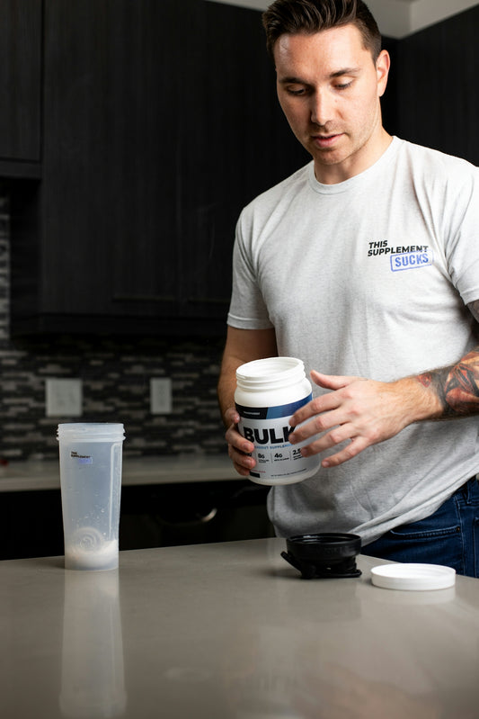 a man holding a cup of coffee in a kitchen