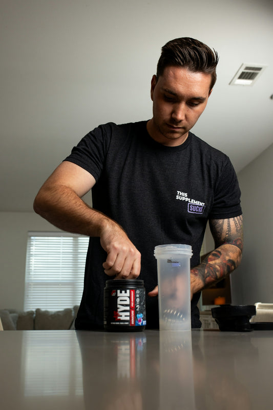 a man standing at a table with a can of drink