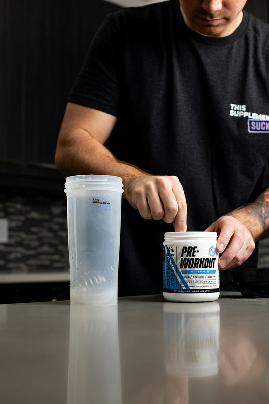 a man holding a can of pre workout on a counter