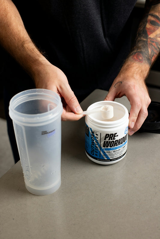 a man holding a spoon over a plastic cup