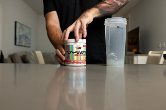 a man with a tattoo on his arm reaching for a jar of pills