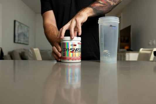 a man with a tattoo on his arm reaching for a jar of pills
