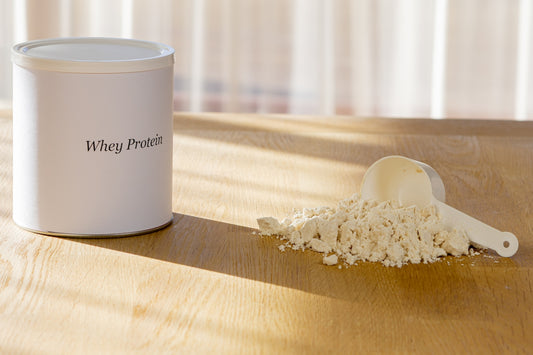 A can of whey protein with a scoop of powder.