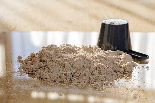 A pile of protein powder with a scoop
